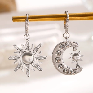 Détail macro de boucles d'oreilles asymétriques soleil et lune argentées avec des cristaux