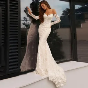 Exquisite white lace embroidery detail on elegant mermaid wedding dress with long sleeves