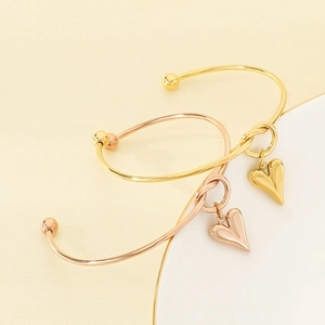 Fashionable stainless steel open bracelets with heart charms in gold and rose gold finishes