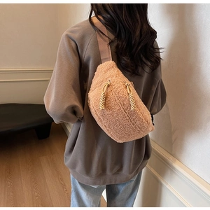 Detail of pink plush crossbody bag featuring a unique woven zipper pull on the back