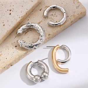 Detailed set of Gothic punk silver and gold ear cuffs and studs on stone props