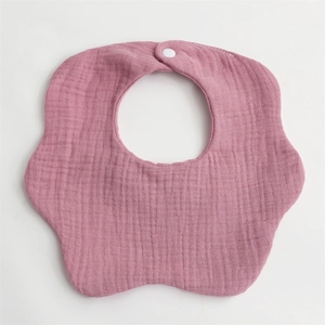 Detail of pink petal-shaped baby bib made of soft 6-layer cotton gauze with snap button