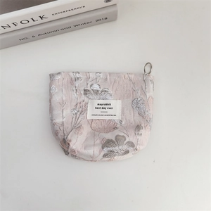 Detail of pink floral corduroy pouch with silver metal zipper and intricate jacquard pattern