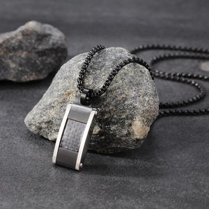 Collier en fibre de carbone style italien avec pendentif en acier sur fond d'ardoise