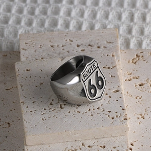 Close-up of titanium steel Route 66 shield ring on a natural stone background