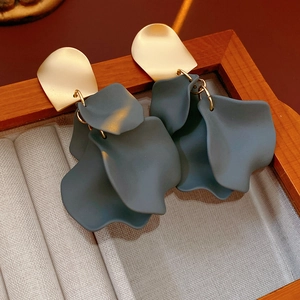 Macro shot of irregular blue flower petals and gold metal studs in a wooden jewelry box
