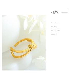Detail view of a gold-plated double-line knot ring with adjustable open band design