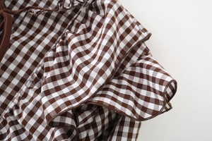 Macro detail of brown gingham fabric texture with layered ruffle and pleated design