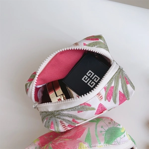 Close-up of small jacquard makeup bag with pink floral pattern and interior storage
