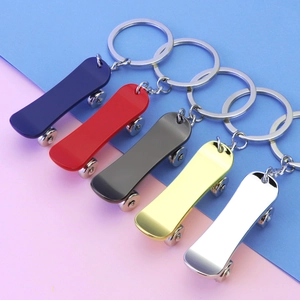 Mini metal skateboard keychains in five colors on a vibrant pink and blue background