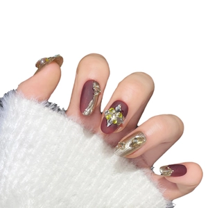 Luxurious matte dark red press-on nails with gold textures and geometric crystal accents
