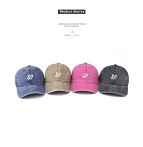 Detailed view of washed cotton baseball caps with double heart embroidery in four colors