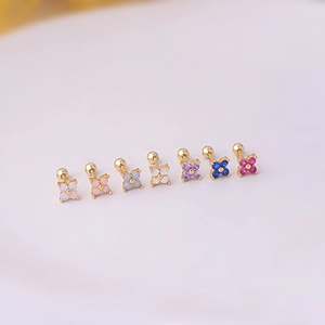 Detailed macro view of seven colorful zircon flower stud earrings with gold screw balls