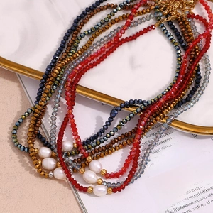Detail of layered beaded necklace with dark crystals and white freshwater pearls