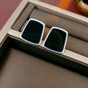 Vue détaillée de boucles d'oreilles géométriques trapèzes en résine noire à bord argent