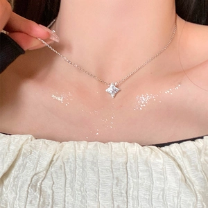 Elegant silver four-pointed star pendant necklace with zircon on a model's neck