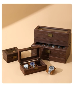 Detail of vintage wood grain watch box featuring a clear glass lid and metal clasp lock