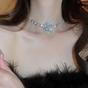 Close-up of a silver rhinestone necklace featuring a 3D rose flower pendant on a model