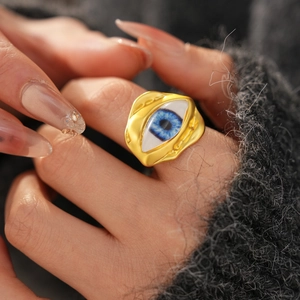 Detail of evil eye ring with irregular hammered texture on a cozy knit background