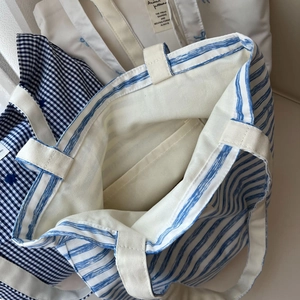 Detail view of cotton tote bag interior with blue stripes and a practical inner pocket