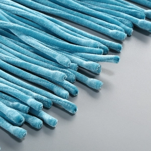 Détail de glands en velours bleu lac avec texture haute résolution sur robe de soirée