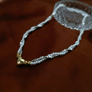 Double-layered pearl and silver bead necklace featuring a gold heart magnetic pendant