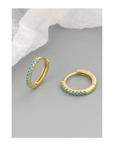 Macro detail of S925 hallmark on gold huggie earrings featuring turquoise stones