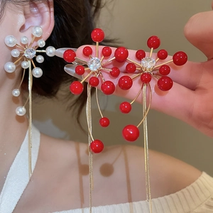 Detailed close-up of vintage flower tassel earrings with pearls and zircon in gold plating