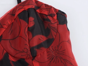 Détail de robe en organza à imprimé floral rouge et noir avec bonnets et fines bretelles