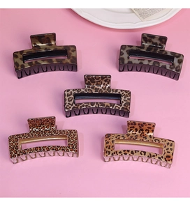 Detailed close-up of five rectangular leopard print hair claws in various earthy tones