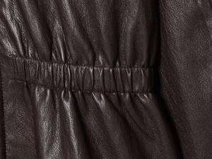 Nahaufnahme der dunkelbraunen Kunstlederjacke mit elastischem Faltenbund und Textur