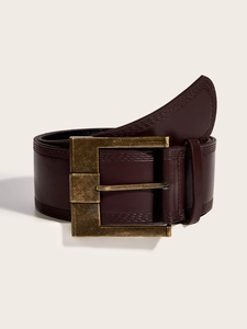 Detail of vintage brown leather belt with bronze metal buckle and double stitching
