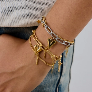 Layered gold and silver chain bracelet with heart and star charms on model's wrist