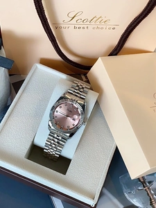 Macro detail of silver steel watch with pink sunray dial and fluted bezel in gift box