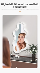 Close-up of modern white wavy wall mirror mounted above a black marble vanity desk