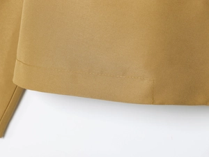 Detailed view of khaki twill fabric with precision double-stitch sewing on the hemline