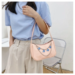 Pink PU shoulder bag detail featuring a silver chain with elegant blue butterfly charms