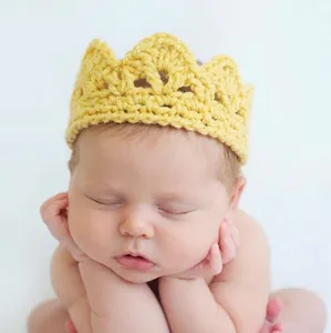 Detail of yellow hand-knitted newborn crown headpiece for baby photo shoots