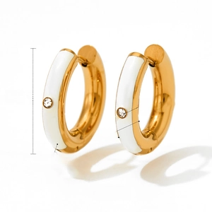 Detail view of 19mm gold stainless steel hoop earrings with white enamel and zircon studs