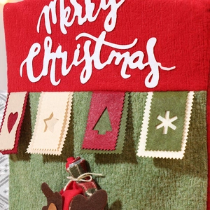 Detail of red and green knitted Christmas chair cover with Merry Christmas embroidery