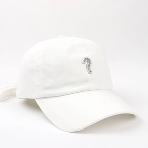 Dettaglio del cappellino in tela bianca con ricamo a punto interrogativo glitter argento