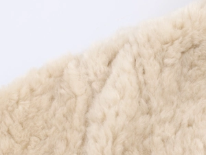 Close-up of soft beige faux fur texture showing premium plush material of the jacket