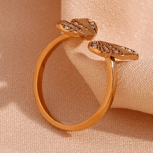 Detailed view of an 18K gold plated butterfly ring with sparkling zircons on silk fabric