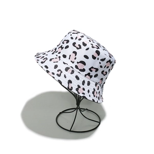 Detail of pink leopard print bucket hat with animal patterns on white canvas fabric