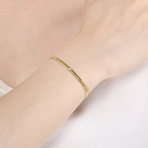 Elegant gold-plated engraved snake chain bracelet for women on wrist in natural light