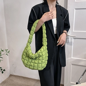 Minimalist green quilted cloud shoulder bag styled with a professional black blazer