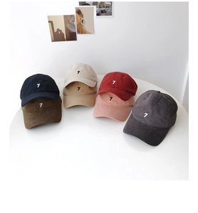 Detailed collection of embroidered cotton baseball caps in multiple colors on a white table