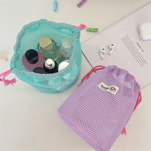 Mesh drawstring storage bags in purple and teal holding cosmetics and skincare products