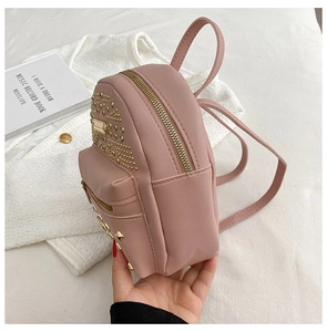 Detailed side view of pink faux leather backpack with gold studs and rhinestone accents