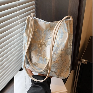 Elegant floral jacquard tote bag with cream leather straps and tassel accessory